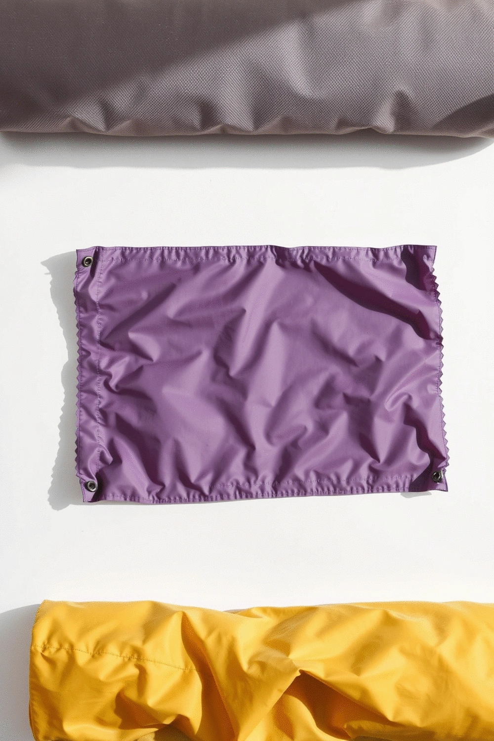 Various yoga mat bag materials: canvas, nylon, and polyester swatches laid out, clean background